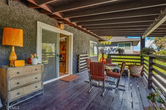 a patio with table and chairs with potted plants