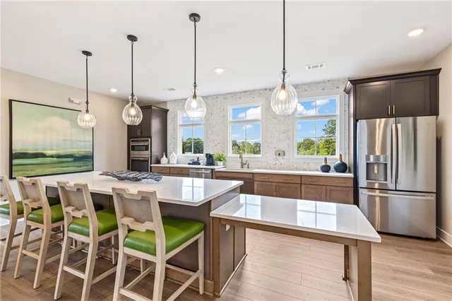 a kitchen with stainless steel appliances granite countertop wooden floor window and wooden floor