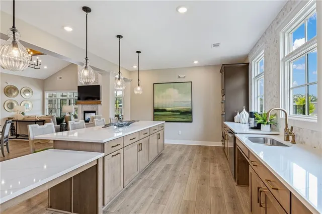a large kitchen with kitchen island a large counter space a sink and wooden floor