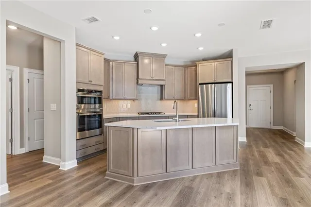 a kitchen with stainless steel appliances granite countertop a stove a refrigerator and a microwave