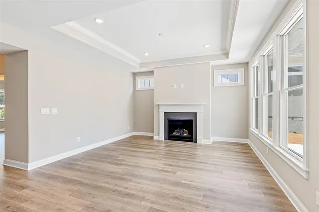 a view of empty room with wooden floor and fireplace