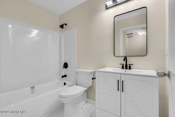 a bathroom with a toilet a sink a mirror and bathtub