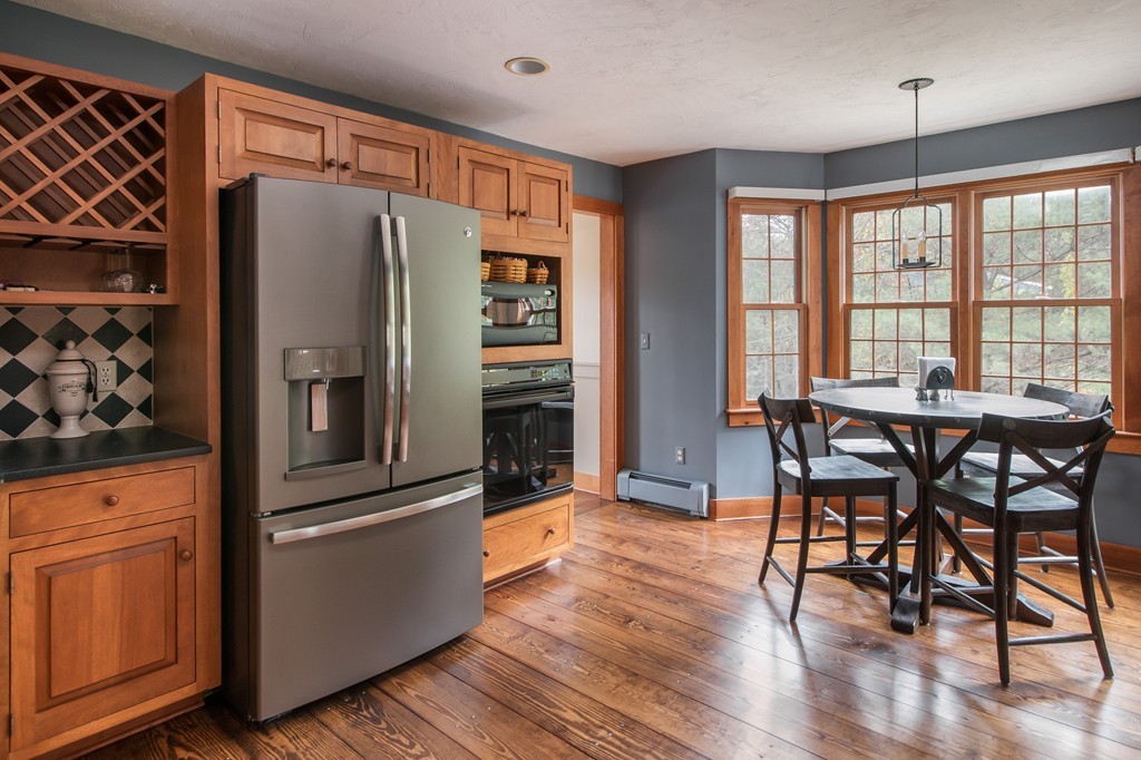 32 Blanchard Road Grafton, MA 01519 - Photo 12 of 30 a kitchen with stainless steel appliances granite countertop a refrigerator a stove and a dining table with wooden floors