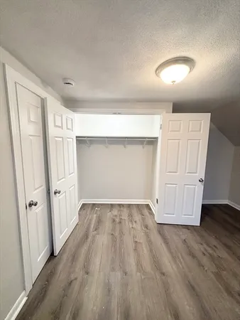 an empty room with wooden floor and white doors