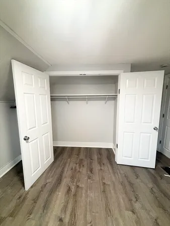 an empty room with wooden floor and cabinet
