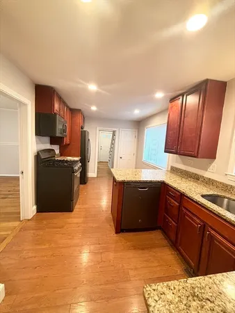 a large kitchen with stainless steel appliances kitchen island granite countertop a refrigerator and a stove top oven