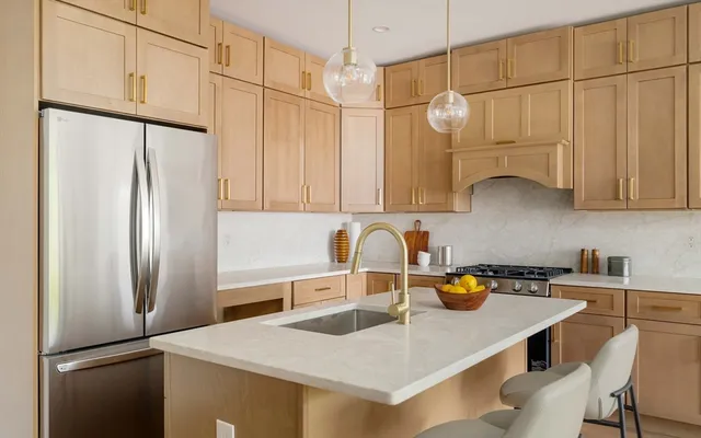 a kitchen with stainless steel appliances a sink a refrigerator and cabinets