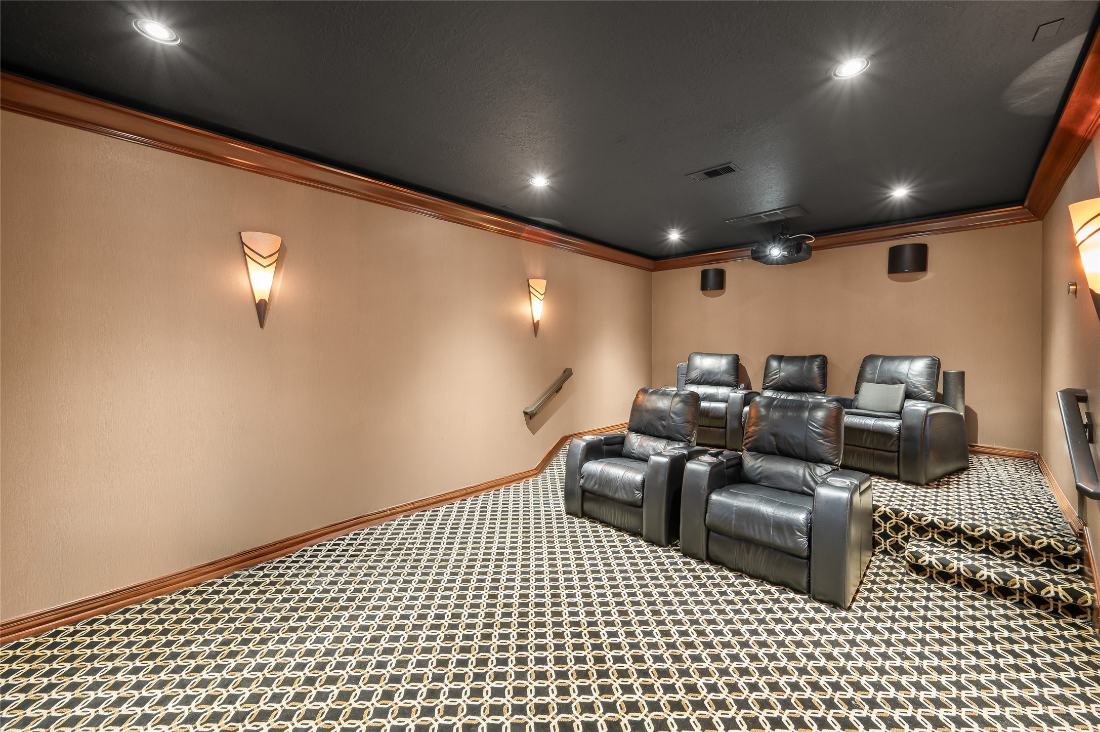 2127 Thicket Ridge Lane Houston, TX 77077 - Photo 19 of 48 Designed for the ultimate viewing experience, this bespoke cinema lounge features tiered stadium seating platforms ensuring every guest has an unobstructed view of the massive 101” screen. This high-performance room is fully equipped with an integrated projector, designer wall sconces, and a discreetly housed under-screen AV rack system. Masterfully positioned just steps from the kitchen, movie nights and game-day entertaining are effortless and immersive.