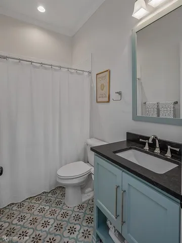 a bathroom with a granite countertop sink toilet and a mirror
