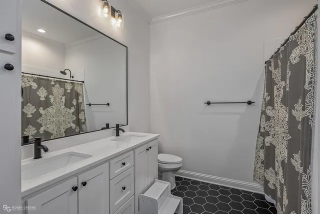 a bathroom with a sink a toilet a mirror and shower