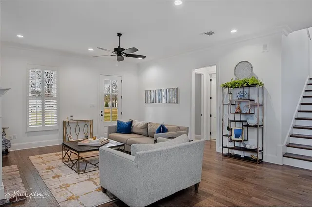 a living room with furniture a bookshelf and a window