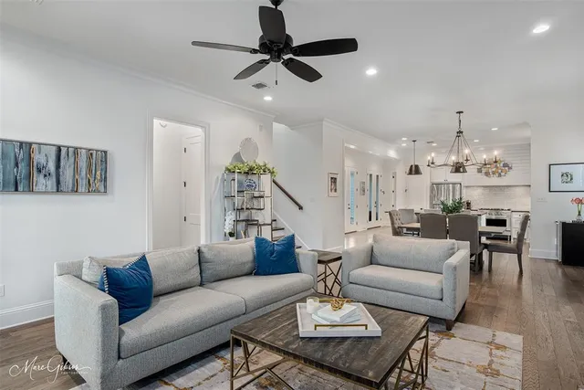 a living room with furniture kitchen view and a chandelier