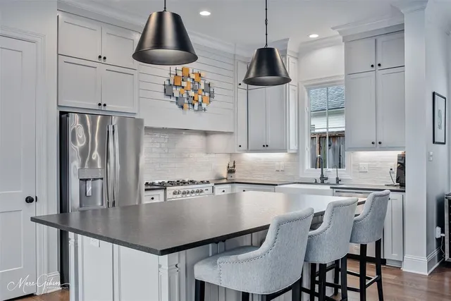 a kitchen with stainless steel appliances granite countertop a sink a stove and refrigerator