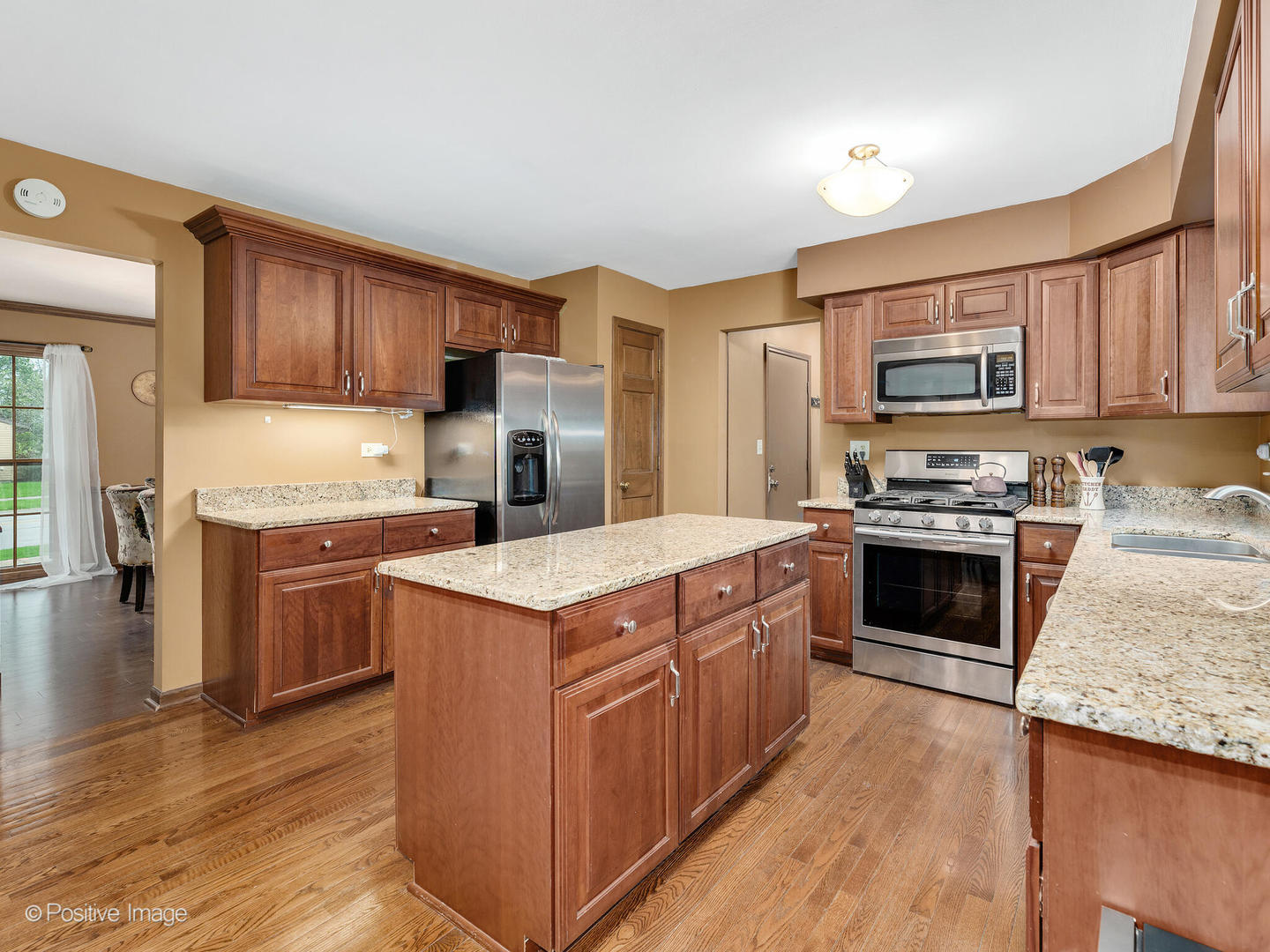 1720 East Bailey Road Naperville, IL 60565 - Photo 11 of 31 a kitchen with granite countertop a stove top oven a sink dishwasher and a refrigerator with wooden floor