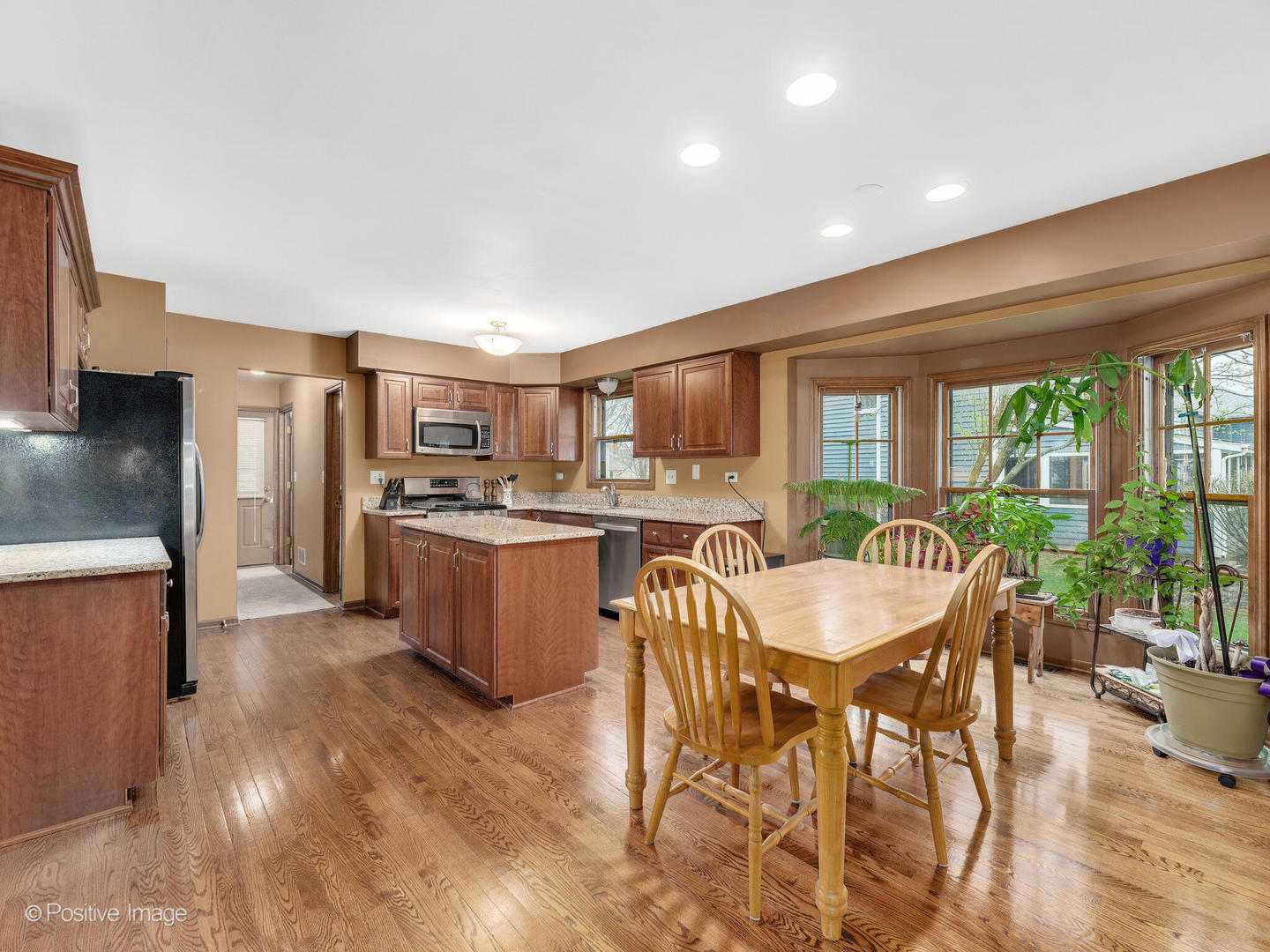 1720 East Bailey Road Naperville, IL 60565 - Photo 9 of 31 a kitchen with stainless steel appliances kitchen island granite countertop a table chairs sink and cabinets