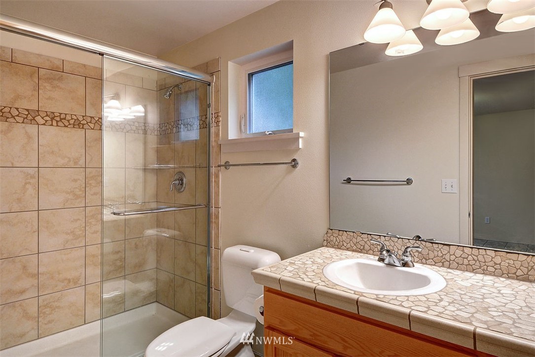 308 North 133rd Street Seattle, WA 98133 - Photo 18 of 18 a bathroom with a granite countertop sink toilet and shower