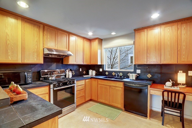308 North 133rd Street Seattle, WA 98133 - Photo 6 of 18 a kitchen with stainless steel appliances granite countertop wooden cabinets a stove top oven a sink and dishwasher