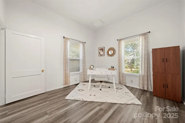 a view of a bedroom with wooden floor and front door