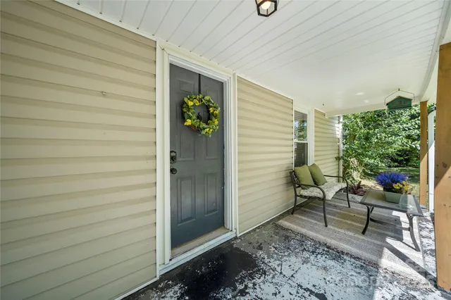 a view of a house with a yard and large tree