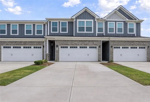 a view of a house with a yard and large garage