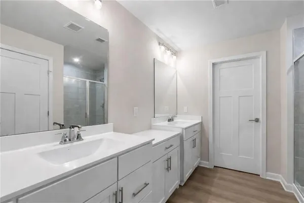 a bathroom with double vanity sinks and a mirror