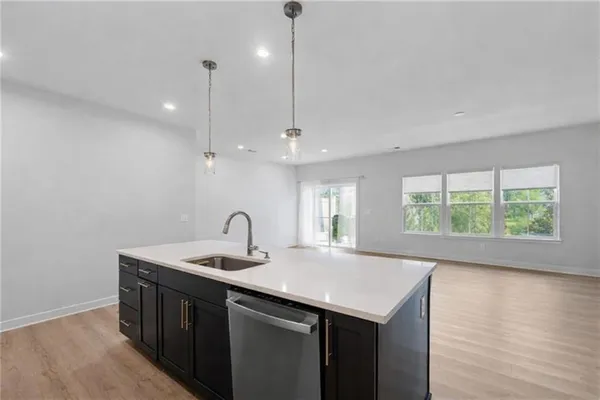 a kitchen with a sink window and wooden floor