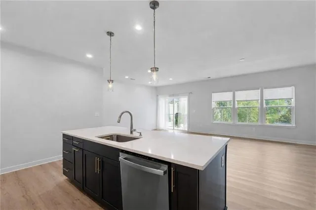 a kitchen with a sink window and wooden floor