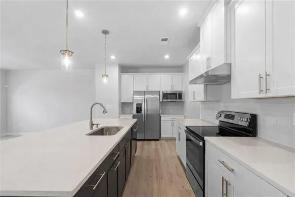 a kitchen with a sink a counter top space stainless steel appliances and cabinets