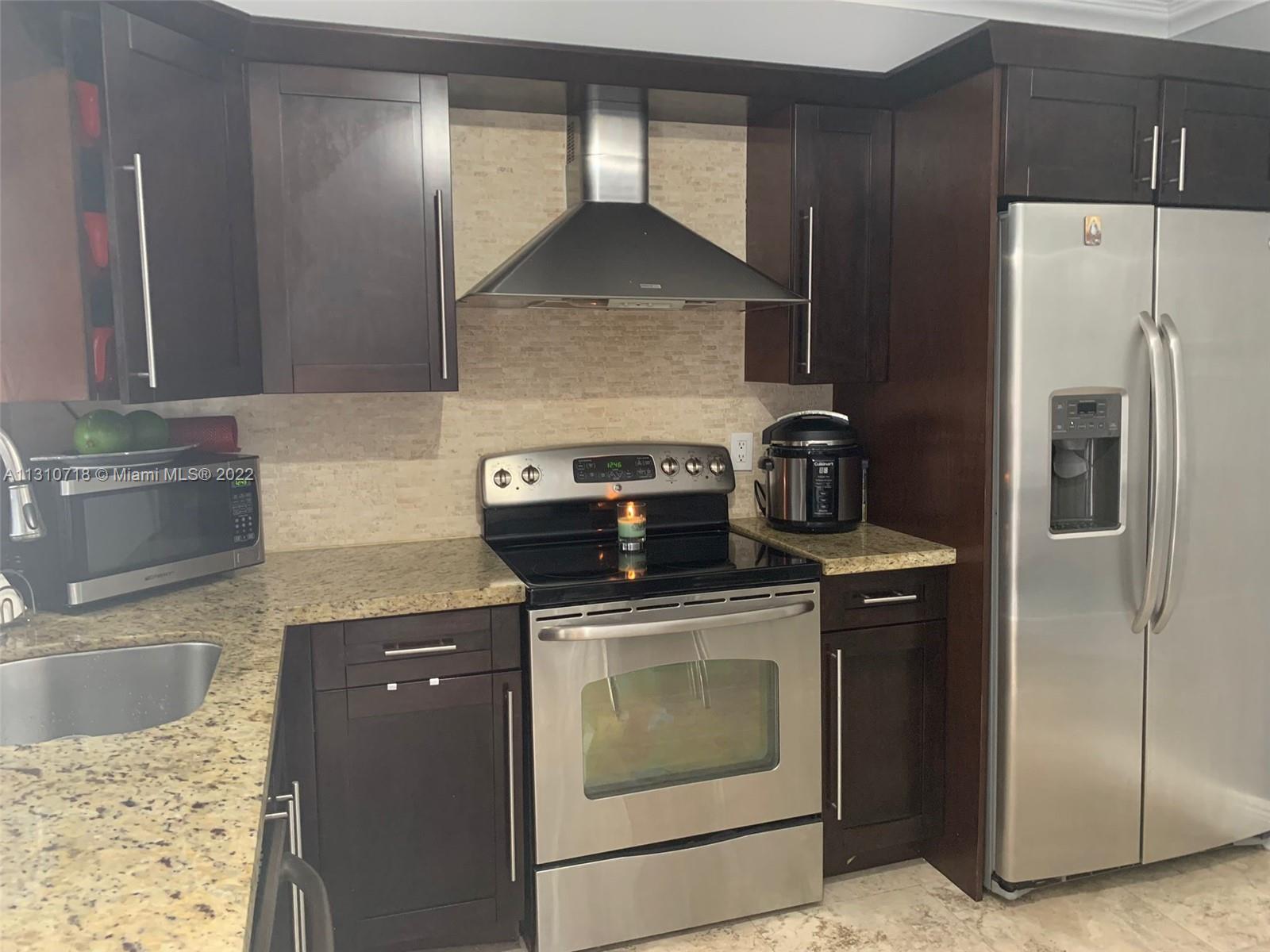 Flagami Miami, FL 33126 - Photo 5 of 21 a kitchen with granite countertop a stove and a refrigerator