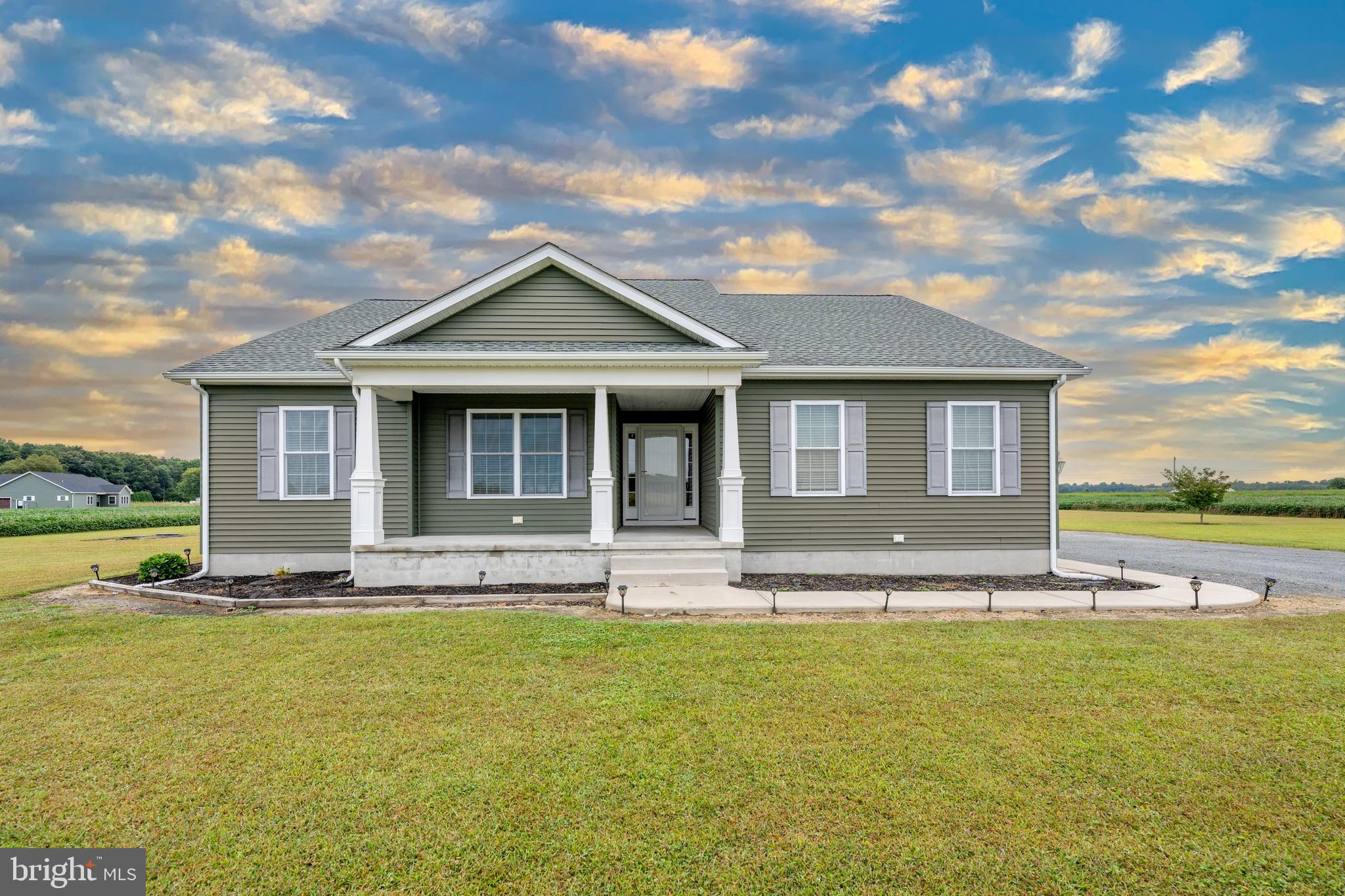 a front view of the house with yard and ocean view