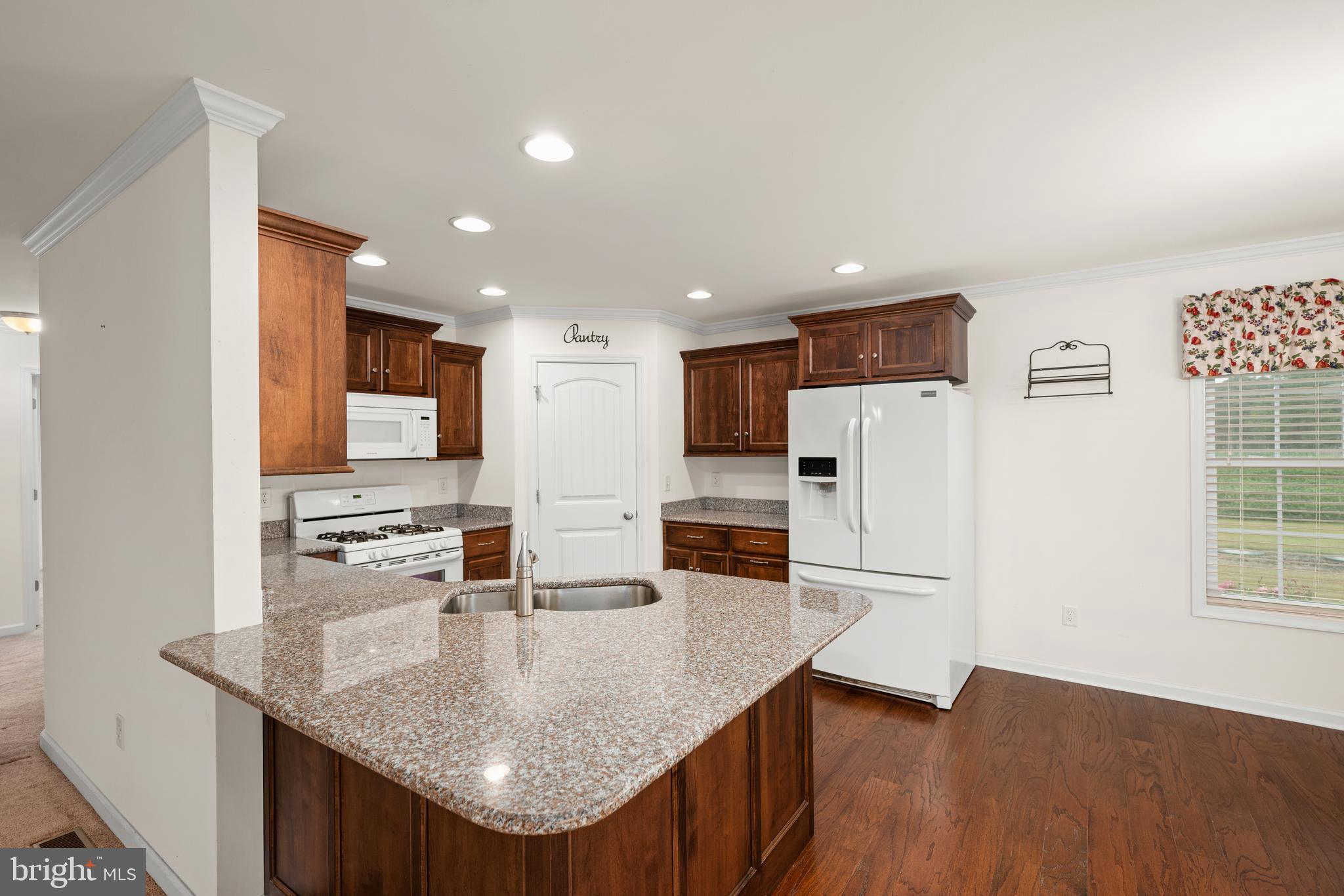 17002 Oak Road Bridgeville, DE 19933 - Photo 6 of 33 a kitchen with stainless steel appliances granite countertop a refrigerator a stove and a sink with wooden floor
