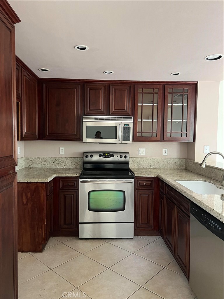 81 Stanford Court, Unit 67 Irvine, CA 92612 - Photo 11 of 30 a kitchen with a sink a stove and cabinets