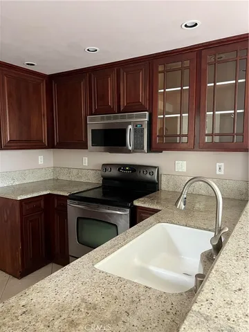 a kitchen with stainless steel appliances granite countertop a stove a sink and a microwave