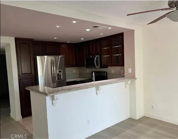 a view of kitchen with stainless steel appliances wooden floor