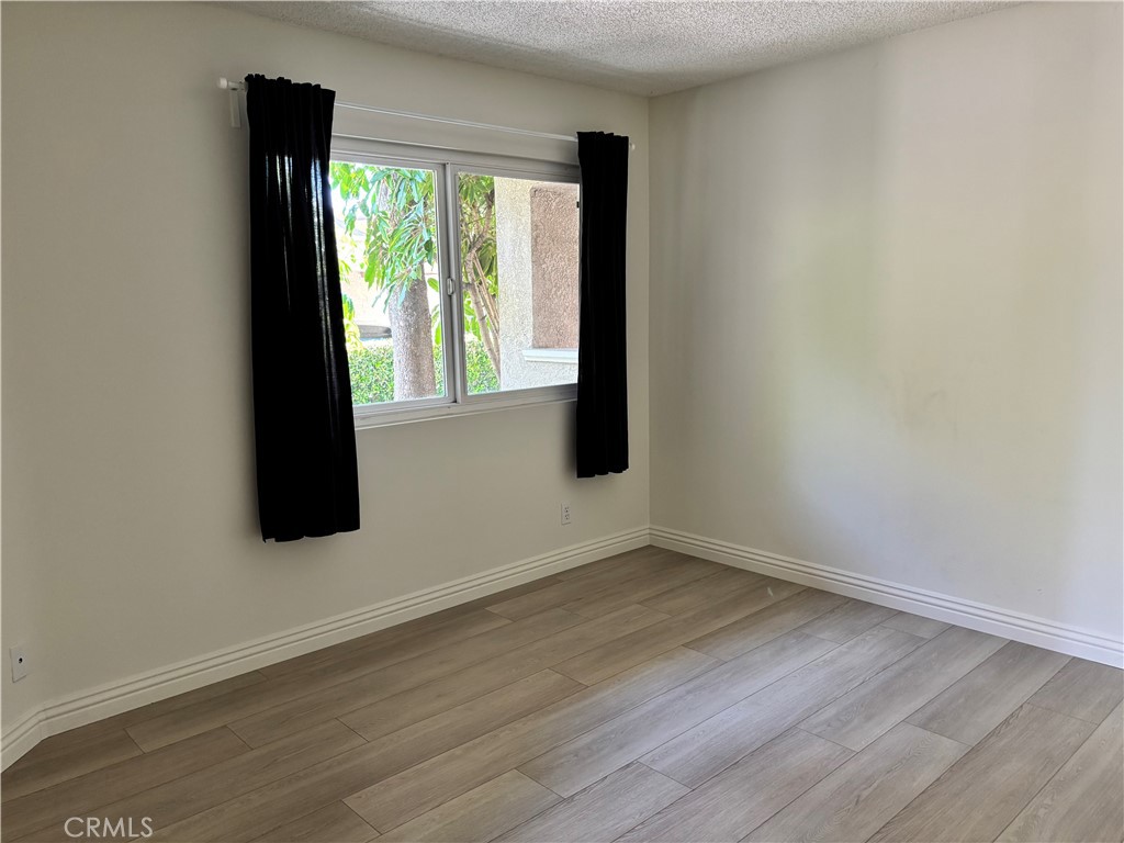 81 Stanford Court, Unit 67 Irvine, CA 92612 - Photo 14 of 30 a view of an empty room with wooden floor and a window