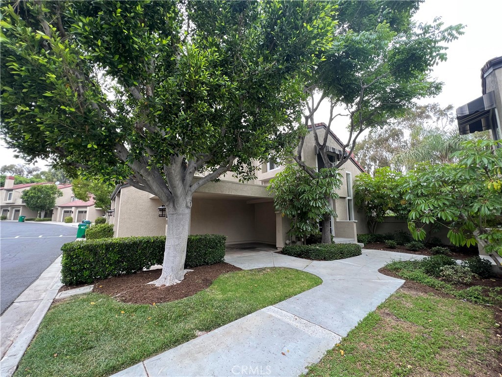 81 Stanford Court, Unit 67 Irvine, CA 92612 - Photo 2 of 30 a front view of a house with a yard and trees