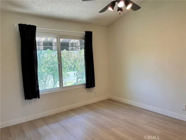 en empty room with windows and ceiling fan