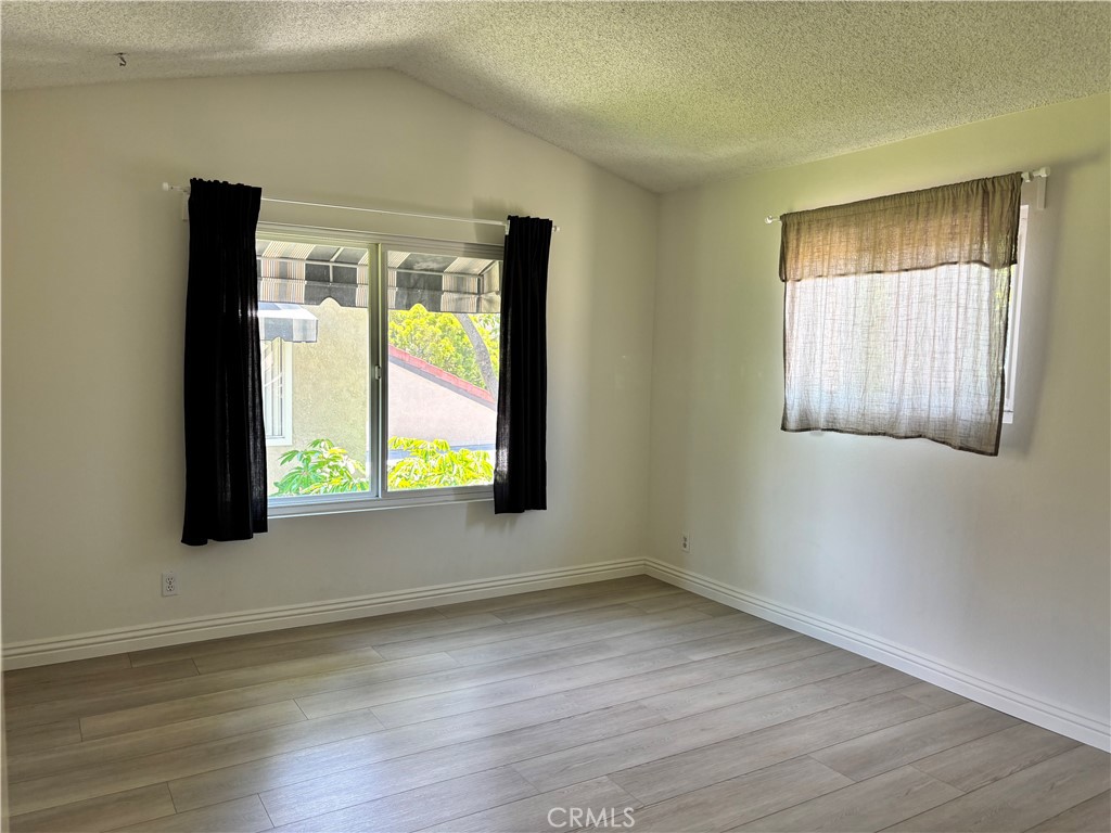 81 Stanford Court, Unit 67 Irvine, CA 92612 - Photo 24 of 30 a view of an empty room with wooden floor and a window