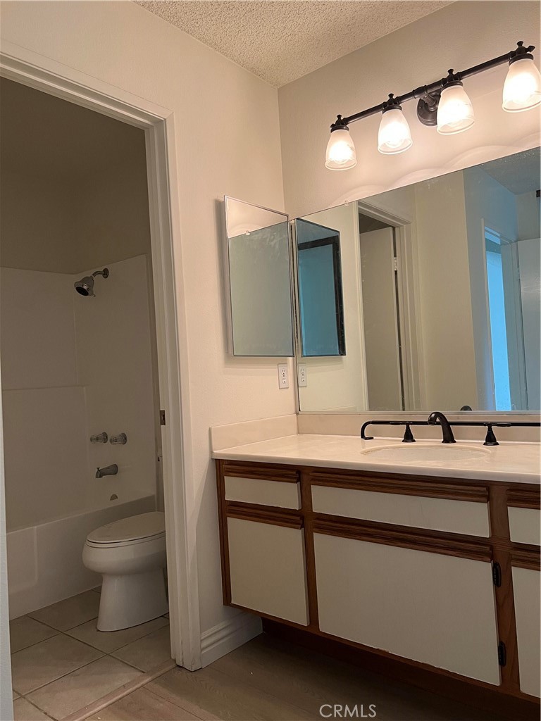 81 Stanford Court, Unit 67 Irvine, CA 92612 - Photo 28 of 30 a bathroom with a double vanity sink toilet and mirror