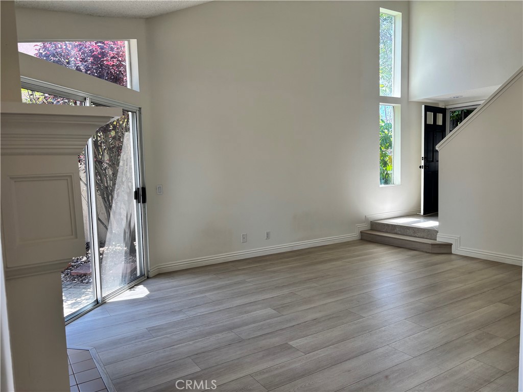 81 Stanford Court, Unit 67 Irvine, CA 92612 - Photo 8 of 30 an empty room with wooden floor and windows