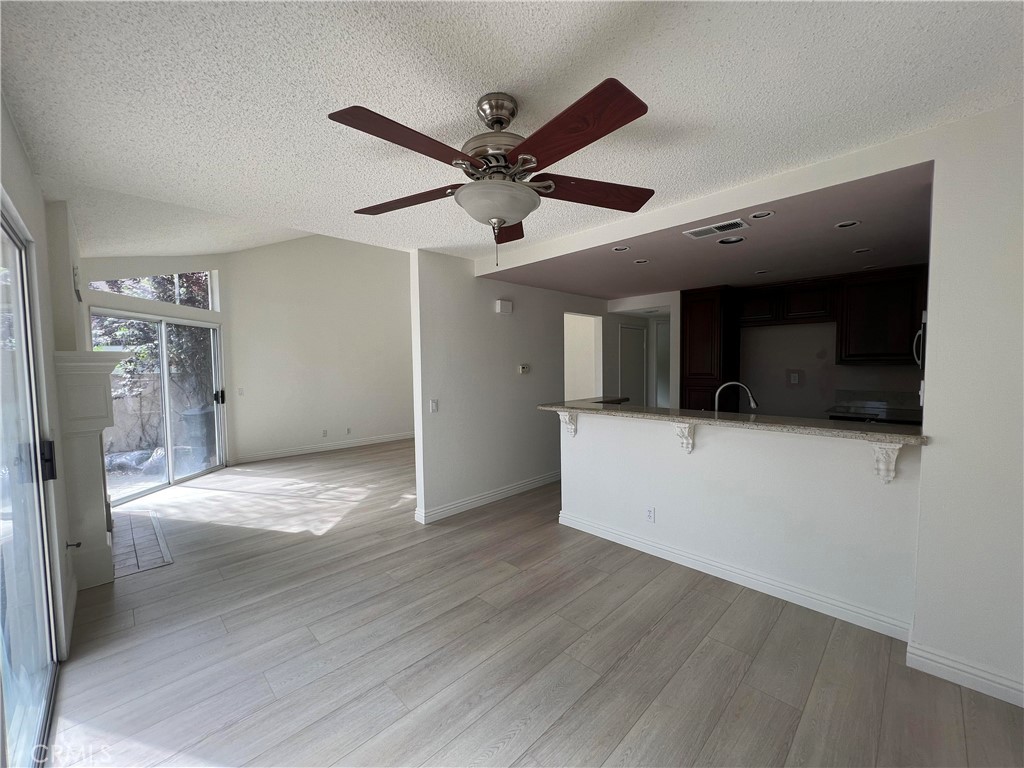 81 Stanford Court, Unit 67 Irvine, CA 92612 - Photo 9 of 30 a view of a livingroom with a ceiling fan wooden floor and a ceiling fan
