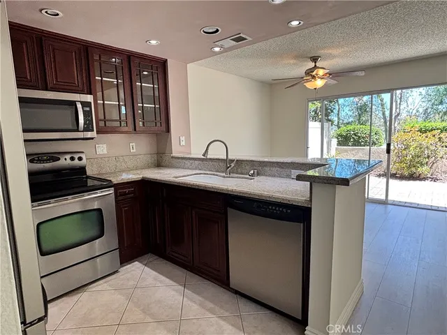 a kitchen with stainless steel appliances granite countertop a sink stove and microwave