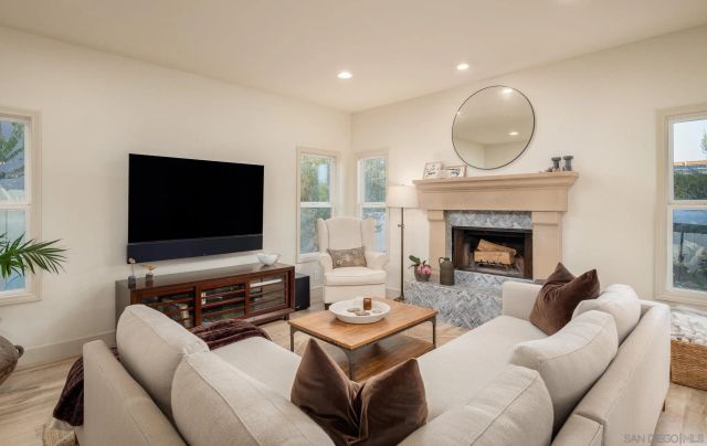 a living room with furniture a flat screen tv and a fireplace