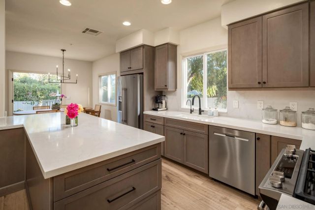 a kitchen with kitchen island a sink stove and refrigerator