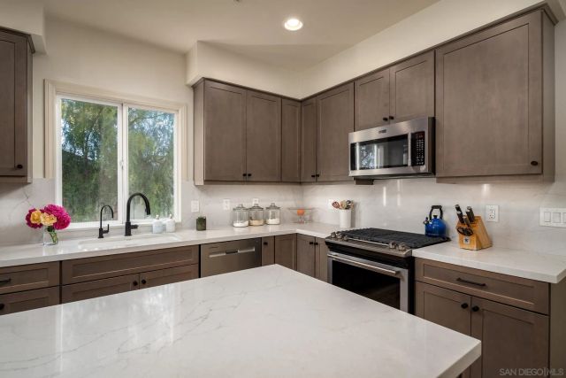 a kitchen with a sink stove top oven and cabinets