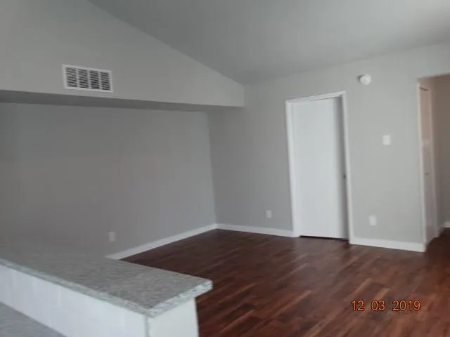 a view of empty room with wooden floor