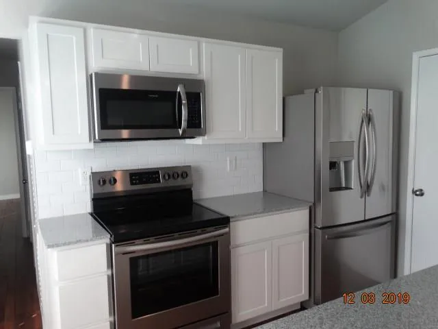 a kitchen with cabinets and stainless steel appliances