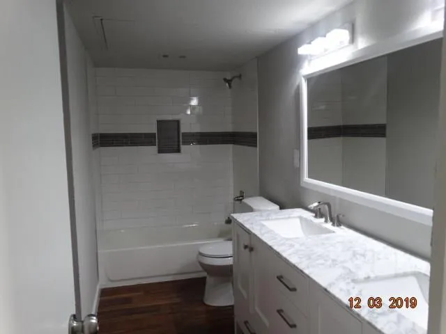 a bathroom with a granite countertop sink a toilet and a bathtub