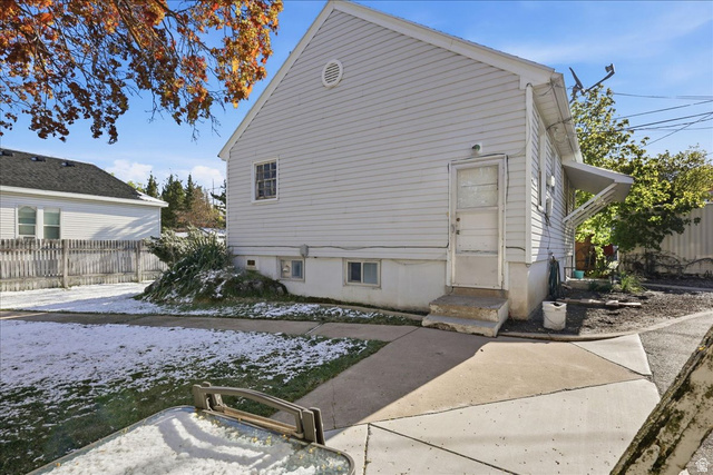 348 East 200 North Logan, UT 84321 - Photo 17 of 41 Rear exterior featuring light-colored siding, a concrete patio, a private entry, and a side yard with a partial fence