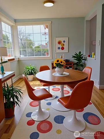 a view of a dining room with furniture one side kitchen view and wooden floor